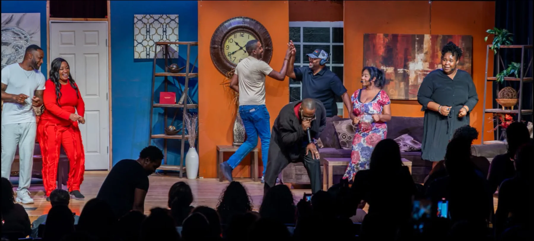 Cast on stage with audience visible in foreground